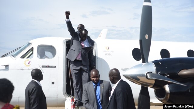 Second-in-command of South Sudan's rebels, Alfred Lado Gore, raises his fist after landing in the capital Juba, after more than two years in exile, April 12, 2016. Rebel leader Riek Machar is scheduled to return on April 18. 