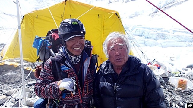 Ючіро Міура (праворуч) і його друг Кенджі Кондо роблять перепочинок під час сходження на гору Еверест, 10 травня, 2013.