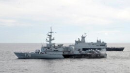 A Royal Malaysian Navy's missile corvette and an offshore patrol vessel are seen during a search and rescue operation for the missing Malaysia Airliner over the Straits of Malacca, Malaysia, March 13, 2014.