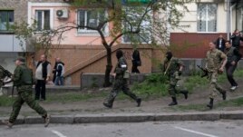 Dân quân vũ trang thân Nga chạy ngang trụ sở cảnh sát địa phương ở Luhansk, miền đông Ukraine, ngày 29/4/2014.