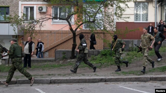 Dân quân vũ trang thân Nga chạy ngang trụ sở cảnh sát địa phương ở Luhansk, miền đông Ukraine, ngày 29/4/2014.