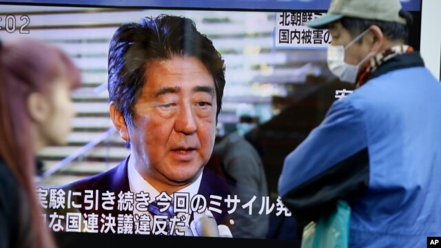 日本东京行人2月7日在街头观看首相安倍晋三就朝鲜发射远程导弹的讲话。