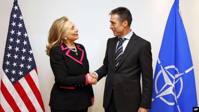 U.S. Secretary of State Hillary Rodham Clinton, left, shakes hands with NATO Secretary-General Anders Fogh Rasmussen at the NATO headquarters in Brussels, December 4, 2012.