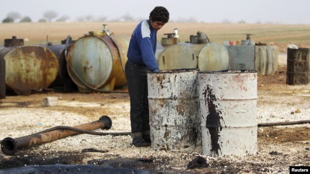 A youth works at a makeshift oil refinery in Syria that, according to its owner, gets crude oil from Islamic State-controlled areas of Syria and Iraq.