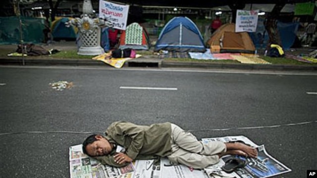 A supporter of the People's Alliance for Democracy, also known as the Yellow Shirts, sleeps on the street near Government House in Bangkok, Thailand, January 27, 2011