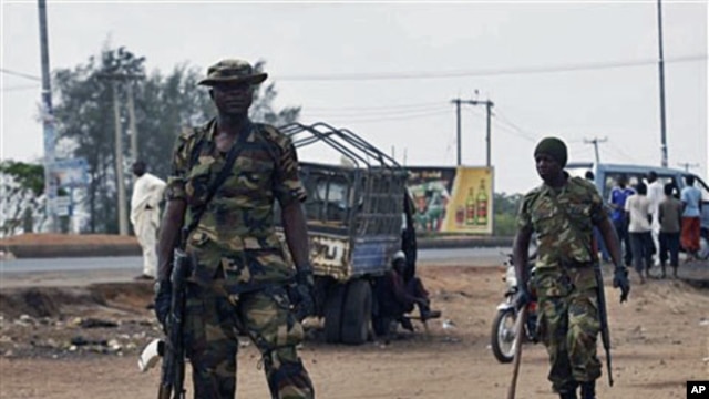 Soldiers stand guard outside the polling station during gubernatorial elections, Kaduna, April 28, 2011