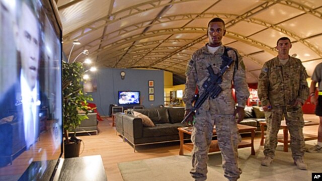 Soldiers watch a rebroadcast of President Barack Obama's speech on a proposed troop withdrawal at Kandahar Airfield, Afghanistan, June 23, 2011