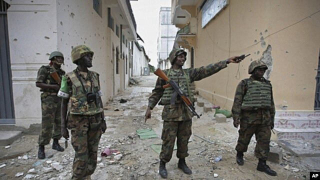In this photo released by the African Union-United Nations Information Support Team, Ugandan soldiers serving with AMISOM patrol through the deserted streets of Bakara Market in central Mogadishu, August 9, 2011 (file photo)