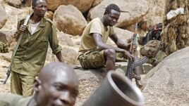 SPLM North rebels practice with a mortar as others watch along the border in South Kordofan, Sudan.