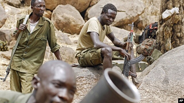 SPLA-N fighters practice with a mortar as others watch near Jebel Kwo village in the rebel-held territory of the Nuba Mountains in South Kordofan, Sudan May 2, 2012.
