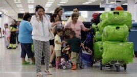 Passengers wait in line for a flight departing to Cuba at Miami International Airport in Miami, Florida, September 27, 2012.