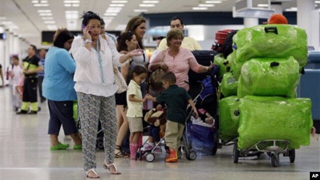 Passengers wait in line for a flight departing to Cuba at Miami International Airport in Miami, Florida, September 27, 2012.