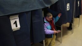 A man exits a polling booth after casting his ballot in Milan, Italy, February 24, 2013.