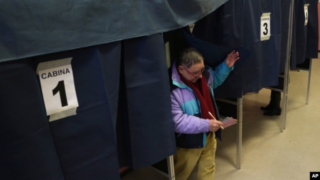 A man exits a polling booth after casting his ballot in Milan, Italy, February 24, 2013.