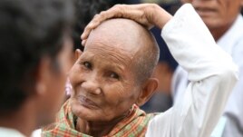 A Cambodian gestures outside the Extraordinary Chambers in the Courts of Cambodia (ECCC) courtroom during the trial of former Khmer Rouge leaders on the outskirts of Phnom Penh Jan. 10, 2012.