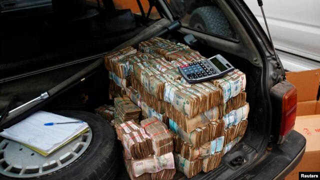 FILE - Money is seen piled in the back of a car in the Democratic Republic of Congo's capital Kinshasa.