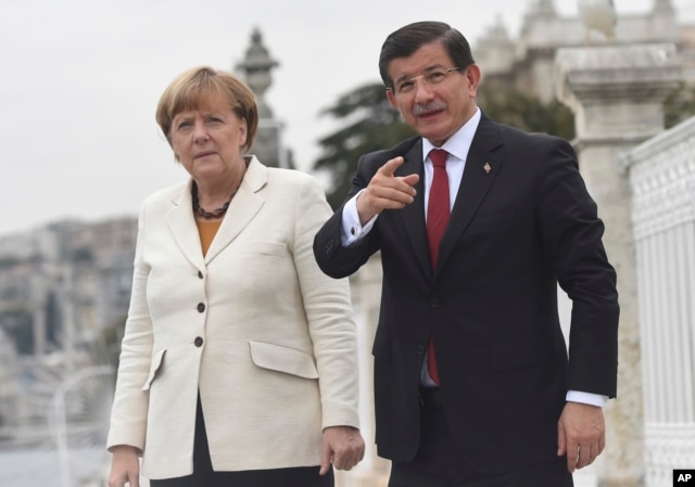 Turkish Prime Minister Ahmet Davutoglu, right, talks to Germany's Chancellor Angela Merkel, left, during their meeting on the grounds of his office in Dolmabahce Palace in Istanbul, Oct. 18, 2015.