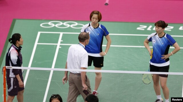 Tournament referee Torsten Berg (3rd R) speaks to players from South Korea (in blue) and Indonesia (in red) during their women's doubles group play stage Group C badminton match during the London 2012 Olympic Games at the Wembley Arena July 31, 2012.