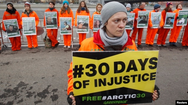 Greenpeace activists hold portraits of those detained on the boat Arctic Sunrise, during a rally in Moscow, Oct. 18, 2013.