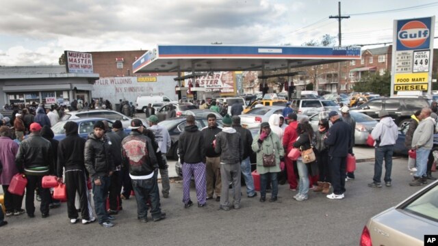 Gas customers on foot with portable containers and lines of vehicles wait for gas pumps to open at a service station, November 3, 2012 in the Brooklyn borough of New York.  