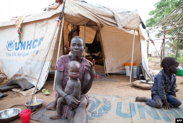 FILE - A woman and her children displaced by fighting in South Sudan sit outside her tent at the Kule camp for Internally Displaced People at the Pagak border crossing in Gambella, Ethiopia, July 10, 2014.