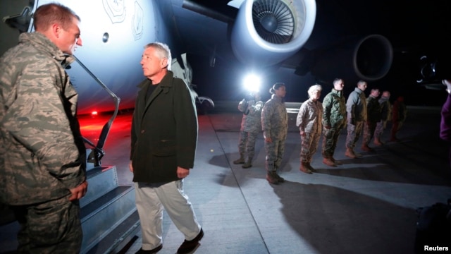 U.S. Secretary of Defense Chuck Hagel prepares to step aboard a C-17 military aircraft en route to Kabul, Afghanistan, after greeting U.S. troops (R ) stationed at Manas Air Force Base in Kyrgyzstan, March 8, 2013.