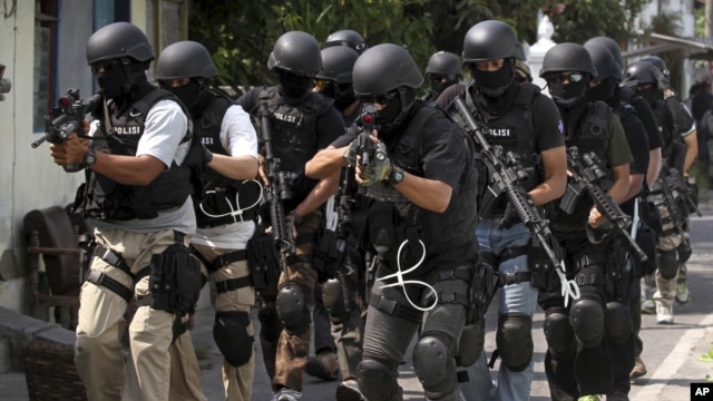 Members of Indonesian police anti-terror unit Special Detachment 88 move into positions as they prepare for a raid in Solo, Central Java, Indonesia, September 26, 2012.