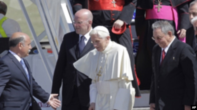Pope Benedict XVI walks with Cuba's President Raul Castro, second right, as he arrives to Antonio Maceo airport in Santiago de Cuba, Cuba, March 26, 2012. 