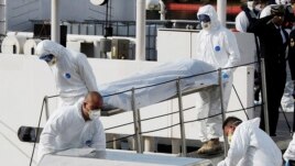 Italian Coast Guard officers carry body of a dead migrant off the ship Bruno Gregoretti, in Valletta's Grand Harbour, Monday, April 20 2015