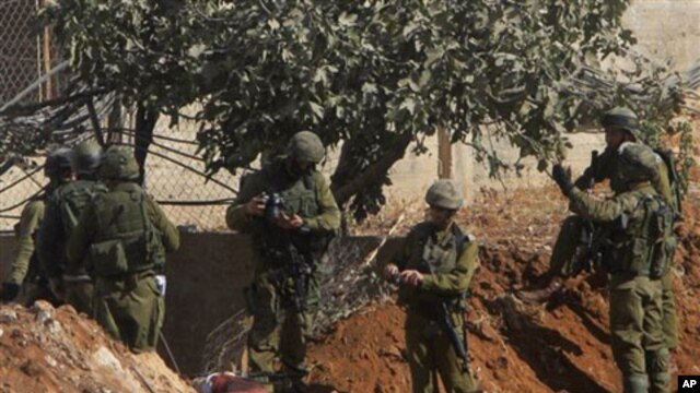 Israeli soldiers inspect the body of senior Hamas militant Nashad al-Karmi, in the West Bank city of Hebron, 08 Oct 2010