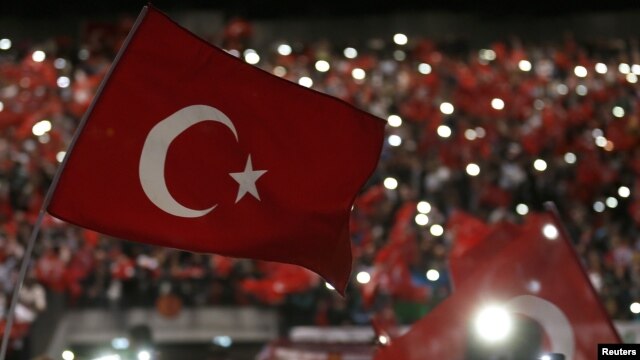 FILE - Supporters of Turkey's President Tayyip Erdogan wave Turkey's national flags as they wait for his speech during a rally against terrorism in Strasbourg, France, Oct. 4, 2015.