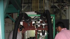 Engineers check the Green Machine, which converts waste heat into electricity, at Southern Methodist University in Dallas, Texas