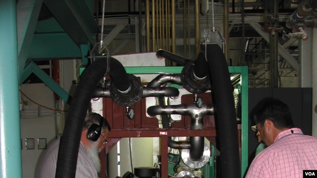 Engineers check the Green Machine, which converts waste heat into electricity, at Southern Methodist University in Dallas, Texas