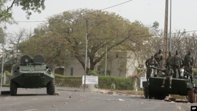 Soldiers secure the area along a road outside the presidential palace after a military coup in Bamako, Mali, Friday March 23, 2012.