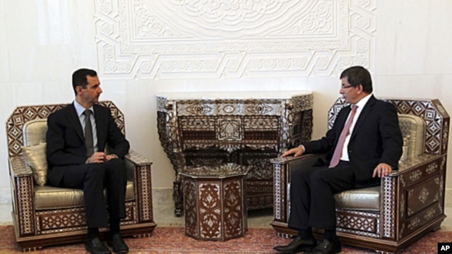 Turkish Foreign Minister Ahmet Davutoglu, right,  meets with Syrian President Bashar al-Assad. in Damascus,  August 9, 2011