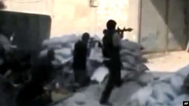 This image made from amateur video released by the Ugarit News, July 15, 2012, purports to show Free Syrian Army soldiers clashing with government forces in Damascus. (AP cannot independently verify the content, date, location or authenticity of this mate