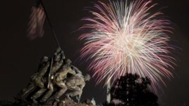 The United States Marine Corps War Memorial, better known as the Iwo Jima Memorial, in Arlington, Virginia, on July 4, 2011, as Independence Day fireworks burst over Washington. The Washington Monument and the Capitol are in the distance.