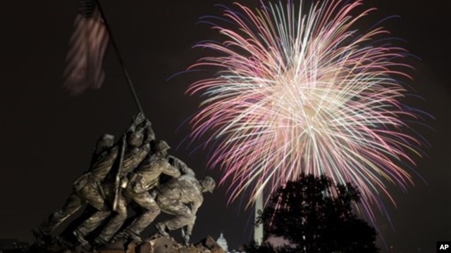 The United States Marine Corps War Memorial, better known as the Iwo Jima Memorial, in Arlington, Virginia, on July 4, 2011, as Independence Day fireworks burst over Washington. The Washington Monument and the Capitol are in the distance.