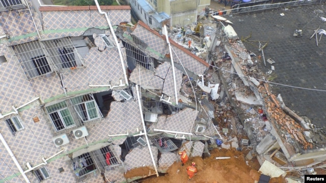 An aerial view shows rescuers looking for survivors at a damaged building after a landslide hit an industrial park in Shenzhen, Guangdong province, China, Dec. 21, 2015.