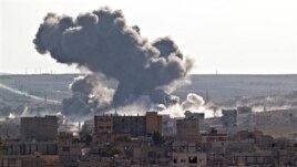 Smoke rises over the Syrian city of Kobani, following a US led coalition airstrike, seen from outside Suruc, on the Turkey-Syria border Monday, Nov. 10, 2014. Kobani