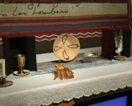 Among the objects on the altar in 'Temple for Pablo Tac' are a chalice, a medicine pouch, and eagle feathers.