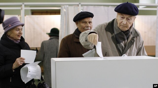  A Lithuanian voter casts his ballot at a polling station in Vilnius, Lithuania, October 14, 2012.