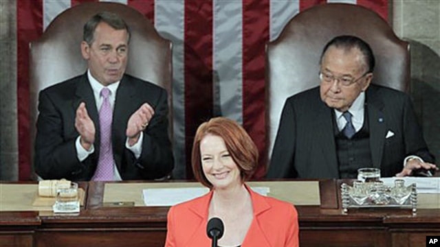 Australian Prime Minister Julia Gillard, center, flanked by Speaker of the House John Boehner, R-Ohio, (l), and Senate President Pro Tempore Daniel Inouye, D-Hawaii, (r), is applauded as she prepares to address a joint meeting of Congress on Capitol Hill 