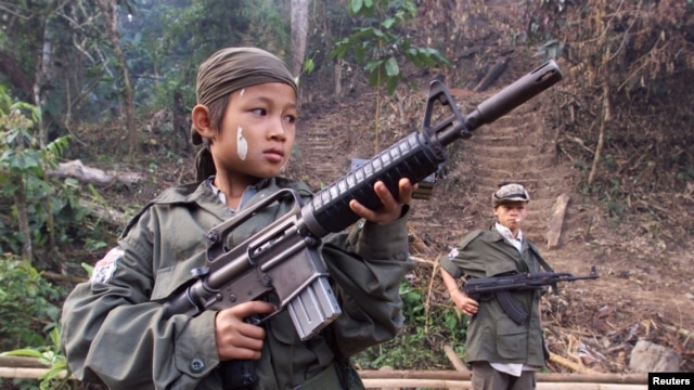 Dalam foto dokumentasi yang diambil tahun 2000 ini, nampak Samboo, seorang bocah berusia 12 tahun tengah berpose dengan senapan miliknya di sebuah hutan dekat perbatasan Thailand. Samboo, salah satu dari tentara anak yang direkrut untuk memperkuat barisan pemberontak Karen untuk melawan pemerintahan militer Burma. (File: dok).