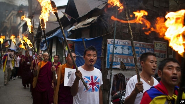 Exile Tibetans carry torches as they participate in a candlelit vigil in Dharmsala, India, June 21, 2012.