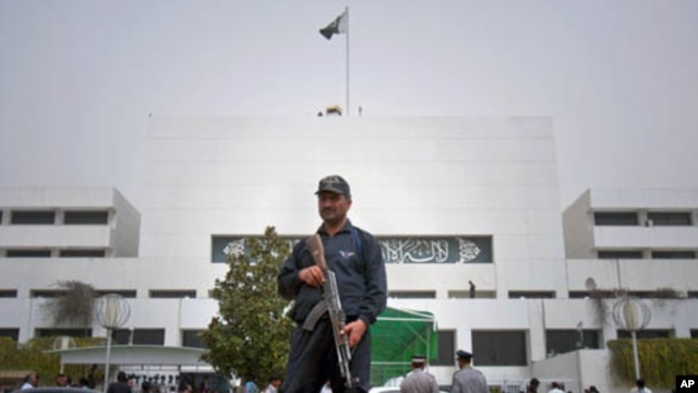 A Pakistani police commando stands guard at the parliament in Islamabad, Pakistan on, March 20, 2012. A special panel met Tuesday to discuss a review of tense relations with the United States. 
