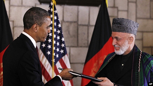 President Barack Obama and Afghan President Hamid Karzai sign a strategic partnership agreement at the presidential palace in Kabul, Afghanistan, May 2, 2012.