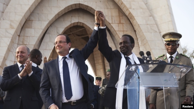 France's President Francois Hollande (2nd L) joins hands with Mali's interim president Dioncounda Traore at Independence Plaza in Bamako, Mali February 2, 2013.