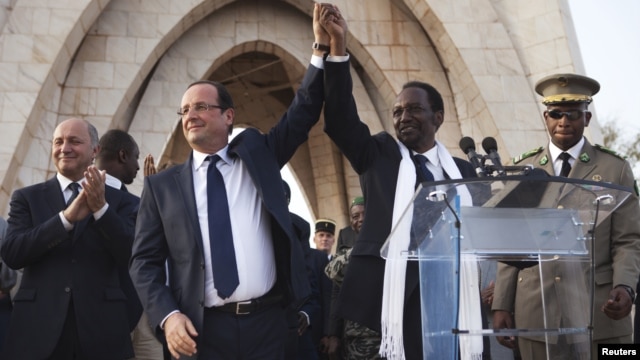France's President Francois Hollande (2nd L) joins hands with Mali's interim president Dioncounda Traore at Independence Plaza in Bamako, Mali February 2, 2013.