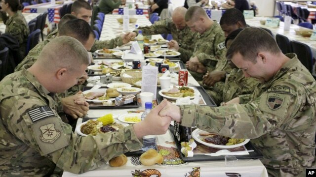 U.S. soldiers pray before eating a Thanksgiving meal at a dining hall at the U.S.-led coalition base in Kabul, Afghanistan, Nov. 22, 2012. 